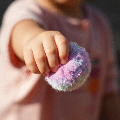 Child's hands creating a DIY Christmas wreath with colorful materials
